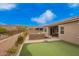 Lush backyard with a putting green and outdoor dining at 9302 W White Feather Ln, Peoria, AZ 85383