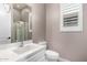 Cozy bathroom featuring a single sink vanity, toilet, and glass-enclosed shower at 9302 W White Feather Ln, Peoria, AZ 85383