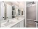 Bathroom featuring double sinks and a view into the bedroom with a ceiling fan at 9302 W White Feather Ln, Peoria, AZ 85383