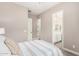 Neutral bedroom showcasing a view into a light and bright bathroom with double vanity at 9302 W White Feather Ln, Peoria, AZ 85383