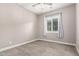 Neutral bedroom showcasing plush carpet and a shuttered window with bright natural light at 9302 W White Feather Ln, Peoria, AZ 85383