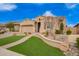 Landscaped front yard featuring desert plants, a rock feature, and a winding walkway leading to the home's entrance at 9302 W White Feather Ln, Peoria, AZ 85383