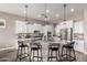 Spacious kitchen featuring a large island with seating, white cabinetry, and stainless steel appliances at 9302 W White Feather Ln, Peoria, AZ 85383