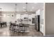 Open kitchen with island, white cabinetry, stainless appliances, pendant lighting, and bar stool seating at 9302 W White Feather Ln, Peoria, AZ 85383