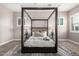 Bright main bedroom featuring a striking four-poster bed, area rug, and shuttered windows at 9302 W White Feather Ln, Peoria, AZ 85383