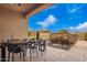 Charming outdoor dining area with a table, chairs, and stone waterfall feature at 9302 W White Feather Ln, Peoria, AZ 85383