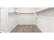 Empty walk-in closet with carpeted flooring, white walls, and custom shelving at 9302 W White Feather Ln, Peoria, AZ 85383