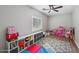 bedroom with laminate floors, ceiling fan, and organized cube storage with play area at 9574 W Quail Ave, Peoria, AZ 85382