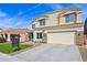 Exterior view of a two-story stucco home with an attached garage and well-maintained artificial turf lawn at 9574 W Quail Ave, Peoria, AZ 85382