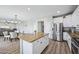 Bright kitchen featuring stainless steel appliances, a large island with granite countertops, and white cabinets at 9574 W Quail Ave, Peoria, AZ 85382