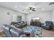 Spacious living room with comfortable leather furniture, ceiling fan, and a large television at 9574 W Quail Ave, Peoria, AZ 85382