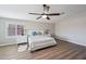 Light filled main bedroom features a ceiling fan, wood-look floors, and two bedside tables with lamps at 9574 W Quail Ave, Peoria, AZ 85382