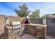 Outdoor kitchen with custom stone-clad grill and pizza oven is perfect for entertaining at 9574 W Quail Ave, Peoria, AZ 85382