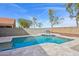 Gorgeous pool with travertine tile decking and raised seating area creates an inviting outdoor oasis at 9574 W Quail Ave, Peoria, AZ 85382