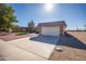 Exterior view of the property showing a two-car garage and desert landscaping at 9813 W Sandstone Dr, Sun City, AZ 85351