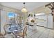 Bright kitchen with white cabinetry, breakfast bar, and sliding glass doors to outside patio at 9813 W Sandstone Dr, Sun City, AZ 85351