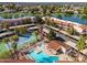 Aerial view of condos near a lake, showcasing a pool, tennis court, and convenient covered parking at 11036 N 28Th Dr # 210, Phoenix, AZ 85029