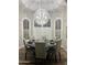 Bright dining room featuring modern chandelier, round table, and large windows with shutters at 11945 N 83Rd Pl, Scottsdale, AZ 85260