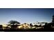Exterior view of a well-lit home at twilight, showcasing its architectural design and serene neighborhood setting at 11945 N 83Rd Pl, Scottsdale, AZ 85260