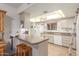 Kitchen featuring a breakfast bar, white appliances, and wood floors at 12510 W Flagstone Dr, Sun City West, AZ 85375