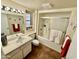 Well-lit bathroom featuring a shower-tub combination with glass doors and a large vanity at 12702 W Ashwood Dr, Sun City West, AZ 85375