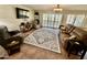 Spacious living room with comfortable seating, decorative rug, and a modern ceiling fan at 12702 W Ashwood Dr, Sun City West, AZ 85375
