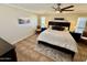 Bedroom features a large bed, tile floor, ceiling fan, neutral walls, and plenty of light at 12702 W Ashwood Dr, Sun City West, AZ 85375