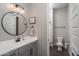 Cozy half bathroom featuring gray vanity, stylish mirror, and a separate toilet room at 12702 W Sierra Vista Dr, Glendale, AZ 85307