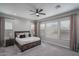 Spacious main bedroom with a king bed, a ceiling fan, curtains, and a window with blinds at 12702 W Sierra Vista Dr, Glendale, AZ 85307