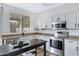 Bright kitchen with stainless steel appliances, a dark island, and white cabinets at 1441 E Erie St, Chandler, AZ 85225