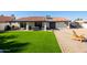 Large backyard features green grass, outdoor seating, a grill, and stone pavers, perfect for entertaining and relaxation at 1501 N Lesueur --, Mesa, AZ 85203