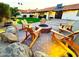 Outdoor fire pit area at dusk is surrounded by comfortable chairs, landscaping, and boulders, perfect for outdoor gatherings at 1501 N Lesueur --, Mesa, AZ 85203
