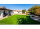 Lush green backyard with an outdoor seating area, built-in grill, pavers, and cozy fire pit for enjoyable outdoor living at 1501 N Lesueur --, Mesa, AZ 85203