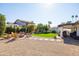 Spacious backyard features a fire pit with Adirondack chairs, green grass, stone pavers, and a covered outdoor living area at 1501 N Lesueur --, Mesa, AZ 85203