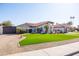 Beautiful single-story home with desert landscaping, green lawn, and a charming facade at 1501 N Lesueur --, Mesa, AZ 85203