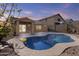 Backyard view of the sparkling pool at dusk, a covered patio, and desert landscaping at 15853 S 17Th Dr, Phoenix, AZ 85045