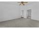 A carpeted bedroom features neutral colored walls, a ceiling fan, and a mirrored closet at 15853 S 17Th Dr, Phoenix, AZ 85045