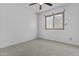 This bedroom features neutral carpet, a ceiling fan, and a window for natural light at 15853 S 17Th Dr, Phoenix, AZ 85045