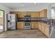 Well-lit kitchen features stainless steel appliances, wood cabinets, granite counters, and decorative backsplash at 15853 S 17Th Dr, Phoenix, AZ 85045