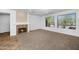 Spacious living room featuring a fireplace, neutral carpet, and large windows at 16918 W Greenbriar Point Ct, Surprise, AZ 85387