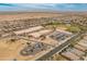 Panoramic aerial view of a sprawling community with schools, homes, and vast desert landscape under a bright blue sky at 17176 W Molly Ln, Surprise, AZ 85387