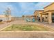 Large backyard features a fire pit area, lush grass, and privacy fence at 17176 W Molly Ln, Surprise, AZ 85387