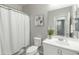 Simple bathroom with a shower curtain, and a vanity with white sink with mirror, and gray accent wall at 17176 W Molly Ln, Surprise, AZ 85387