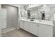 Bright bathroom with dual sinks, large mirror, and wood-look flooring at 17176 W Molly Ln, Surprise, AZ 85387