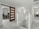 Bright hallway featuring a sliding barn door entry to an office space with gray carpet at 17176 W Molly Ln, Surprise, AZ 85387