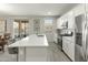 Well-lit kitchen with large center island, stainless steel appliances, and sliding doors to the outside patio at 17176 W Molly Ln, Surprise, AZ 85387