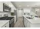 Modern kitchen features stainless steel appliances, white cabinets, and a convenient center island with a sink at 17176 W Molly Ln, Surprise, AZ 85387