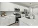 Contemporary kitchen is equipped with stainless steel appliances, white cabinets, and a functional center island at 17176 W Molly Ln, Surprise, AZ 85387