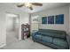 Comfortable living room with a blue sofa, bookshelf, and ample natural light from the window at 17176 W Molly Ln, Surprise, AZ 85387