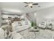 Bright living room boasts a ceiling fan, modern furniture, and blends seamlessly into the dining area at 17176 W Molly Ln, Surprise, AZ 85387